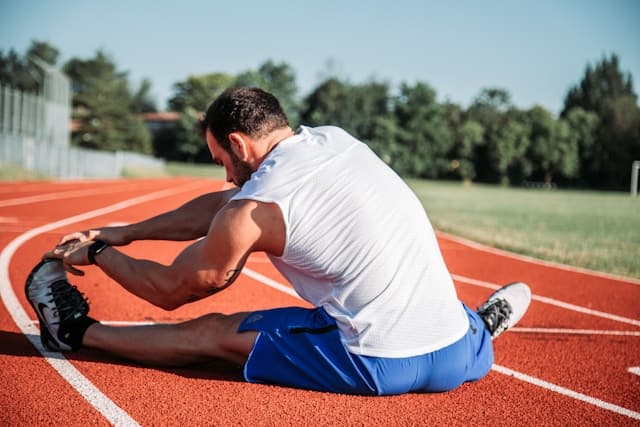Runner stretching their calf in the morning sun
