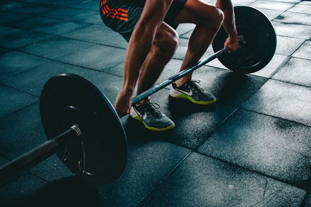 Hardloper en sporter die lunges doen in een sportschool